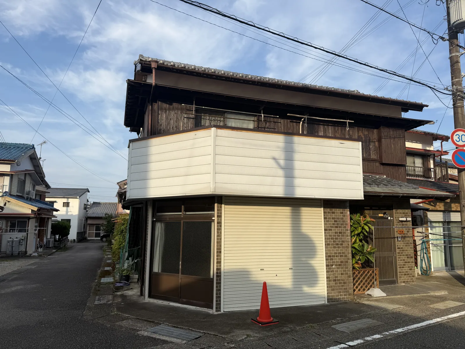 那智勝浦町天満の中古戸建の外観。道路沿いに建つ木造2階建てと1階のシャッター部分