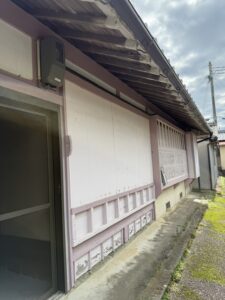 那智勝浦町下里の中古戸建の外観。下見板張りの白い壁と薄紅色の柱
